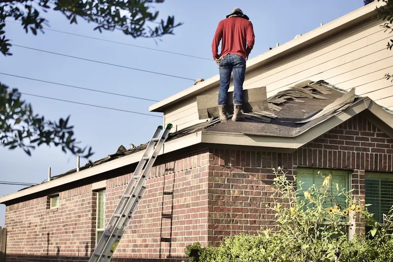 Professional roofer working on a residential roof in Montague